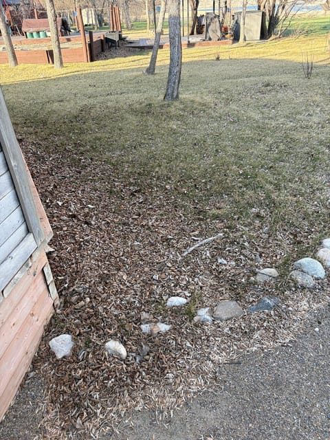 Before the spring cleanup: Rock border by the planter